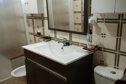 a bathroom with a white sink and a toilet at Casa rural Balcón de Monachil in Monachil