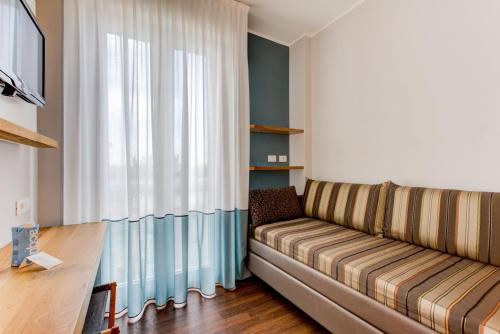 een woonkamer met een bank en een tafel bij BeYou Hotel Polo in Riccione