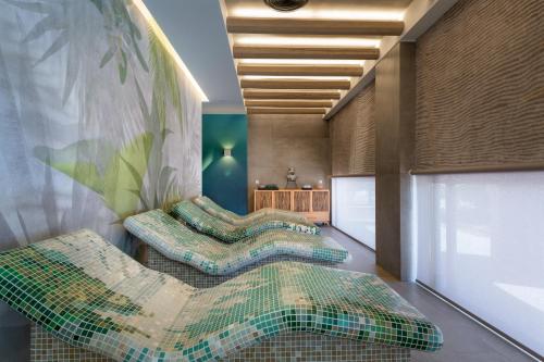 Zimmer mit 3 grünen Stühlen und einer Wand in der Unterkunft Porto Angeli in Archangelos