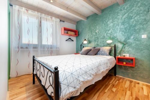 1 dormitorio con cama y pared verde en La picia en Rovinj