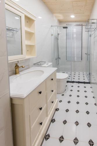 a white bathroom with a sink and a shower at Good Times BnB in Chishang