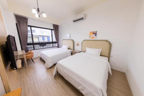 a hotel room with two beds and a television at Good Times BnB in Chishang