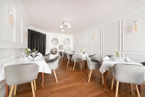 a dining room with white tables and chairs at IBB Hotel Grand Hotel Lublin in Lublin