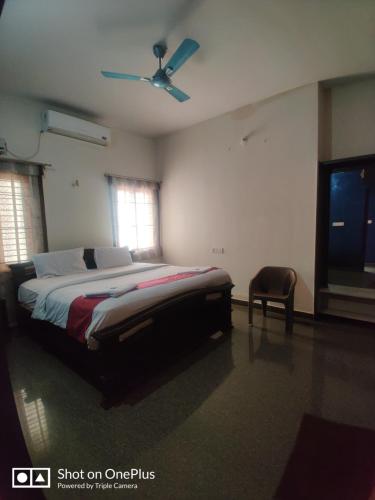 a bedroom with a bed and a ceiling fan at Nandana Home stay in Mysore