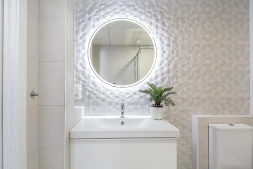 uma casa de banho branca com um lavatório e um espelho em Sunset Beach II em Santa Pola