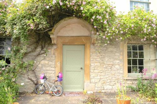 ein Fahrrad parkt vor einem Haus mit grüner Tür in der Unterkunft Lovely property in the heart of Somerset, sleeps 9 in Shepton Mallet
