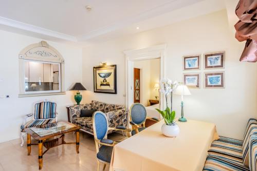 a living room with a couch and a table and chairs at Guadalpin Suites in Marbella