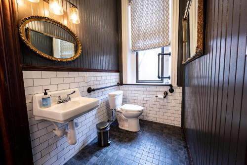 uma casa de banho com um lavatório, um WC e um espelho. em Traveler's Rest Hotel em Pittsburgh