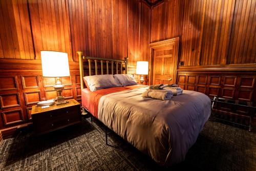 a bedroom with wooden walls and a bed with two lamps at Traveler's Rest Hotel in Pittsburgh