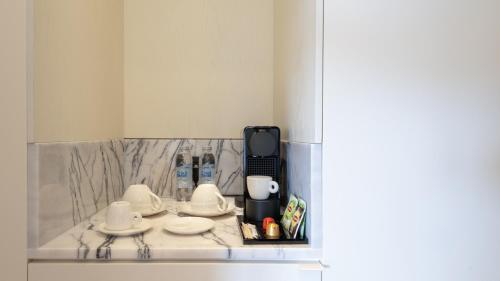 a kitchen with white cups and saucers on a counter at The Gift Hotel in Istanbul