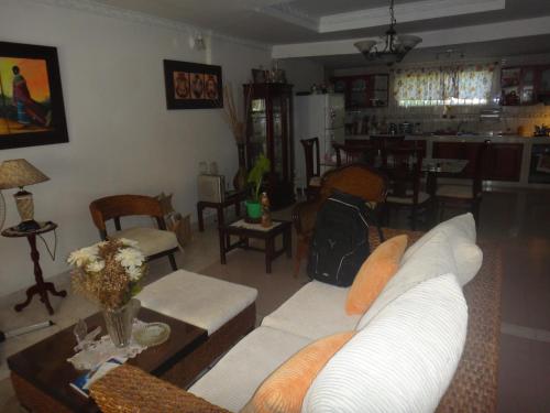 a living room with a white couch and a table at Green Sea Villa Helen Inn, Kilometer 4 Circunvalar in La Loma