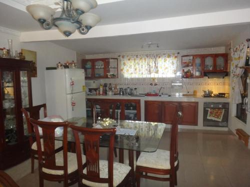 a kitchen with a table and chairs and a refrigerator at Green Sea Villa Helen Inn, Kilometer 4 Circunvalar in La Loma