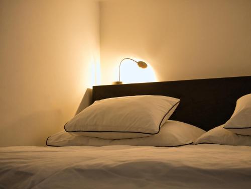 ウィーンにあるexklusiv Studioのベッド(白い枕、ランプ付)