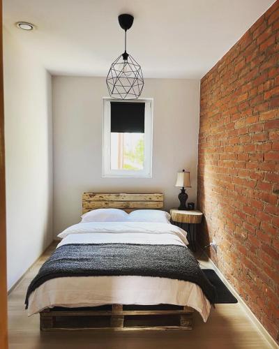 a bedroom with a large bed and a brick wall at Pod Świerkami in Zakrzówek