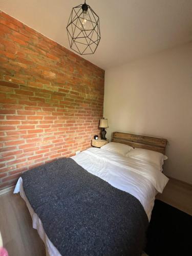a bedroom with a brick wall and a bed at Pod Świerkami in Zakrzówek