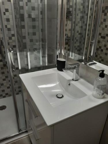 La salle de bains est pourvue d'un lavabo blanc et d'une douche. dans l'établissement Iris340Benalmádena, à Benalmádena