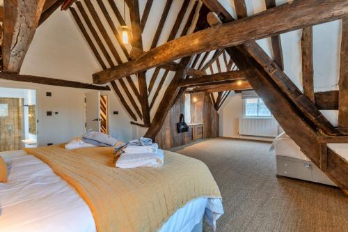 um quarto com uma cama grande e vigas de madeira em Finest Retreats - The Half-ARC of Painswick em Painswick