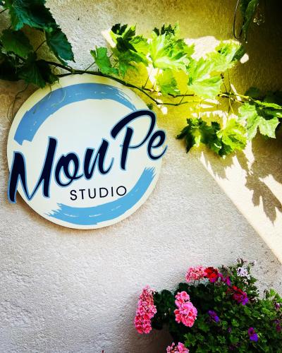 a sign for a north pe studio on a wall with flowers at MonPe apartmánik s atmosférou in Komárno