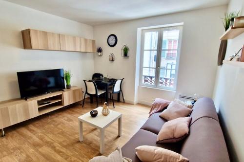 uma sala de estar com um sofá e uma mesa em Appart'Hôtel - Le Sweet Cosy em Fontainebleau