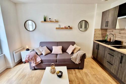uma sala de estar com um sofá e uma cozinha em Appart'Hôtel - Le Sweet Cosy em Fontainebleau