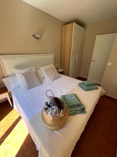 a bedroom with a bed with a basket on it at Bonito apartamento con terraza, jardín y piscina in Cala en Bosc