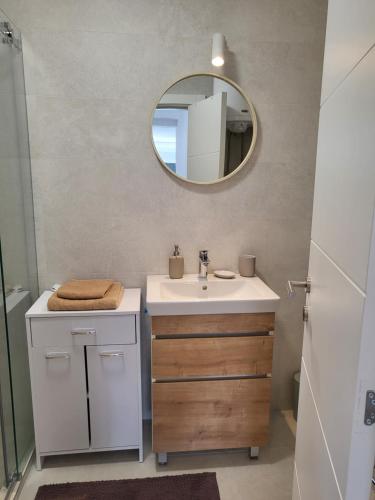 a bathroom with a sink and a mirror at Apartman Mela Kop 11 in Kopaonik