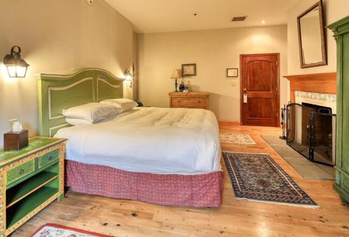 a bedroom with a large bed and a fireplace at Wedmore Place in Williamsburg