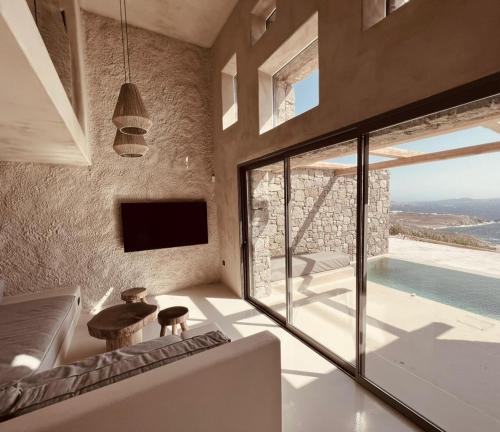 a living room with a couch and a large window at Ria Mar Suites in Mýkonos City