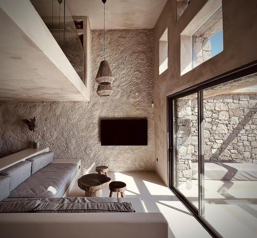 a room with a bed and a tv on a wall at Ria Mar Suites in Mýkonos City
