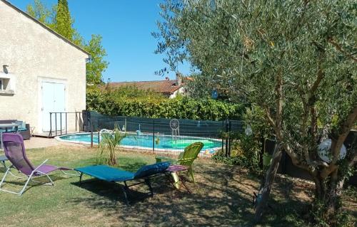 einen Garten mit zwei Stühlen und einem Pool in der Unterkunft Chambres d'hôtes & jacuzzi - A l'ombre des amandiers in Saint-Martin-dʼArdèche