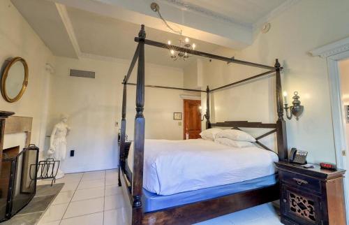 a bedroom with a four poster bed in a room at Wedmore Place in Williamsburg