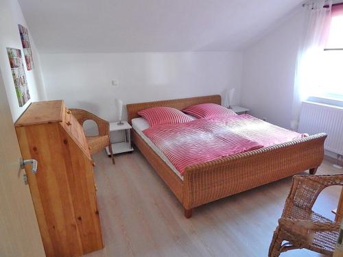 um pequeno quarto com uma cama e piso em madeira em Ferienwohnungen Bergidyll em Sachrang