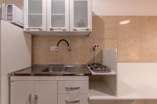 a small kitchen with a sink and a refrigerator at BH Studios Hotel Brás in Sao Paulo