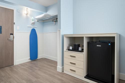 a room with a refrigerator and a surfboard on the wall at Fenwick Inn in Ocean City