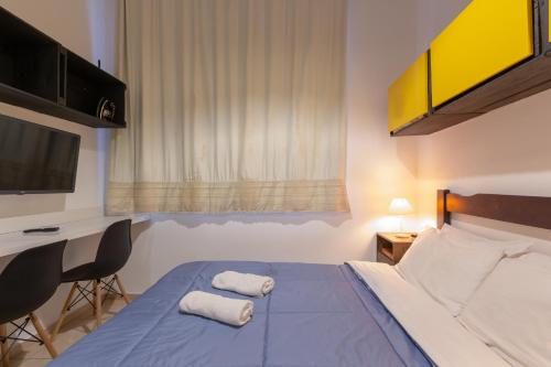 a bedroom with a bed with two towels on it at BH Studios Hotel Brás in Sao Paulo