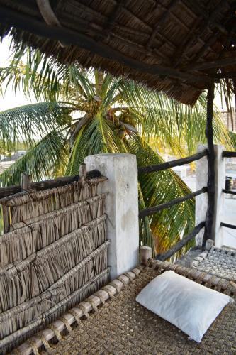 拉穆的住宿－JamboHouse Lamu，枕头坐在墙上的地面上