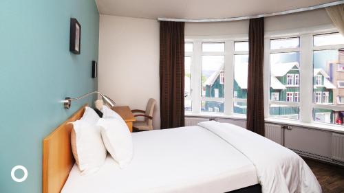 Un dormitorio con una cama grande y una ventana en Center Hotels Klopp, en Reikiavik