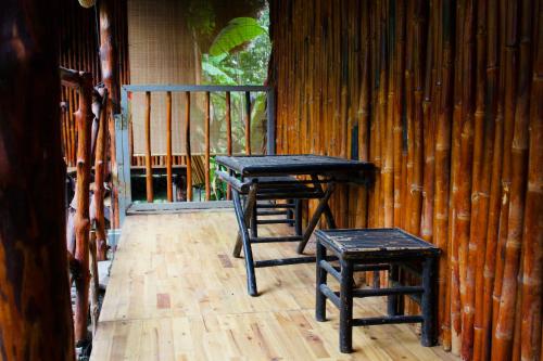 a pair of tables and stools on a porch at Saigon Garden Homestay in Ho Chi Minh City