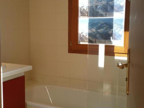 a bathroom with a bath tub and a window at Studio Valloire, 1 pièce, 2 personnes - FR-1-263-483 in Valloire