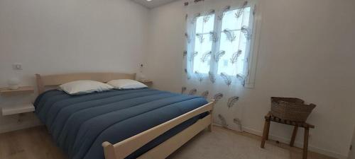 - une chambre avec un lit doté d'une couverture bleue et d'une fenêtre dans l'établissement "Les Orchidées" Cosy et rénové, Proche Mer, Gare, à Roquebrune-Cap-Martin