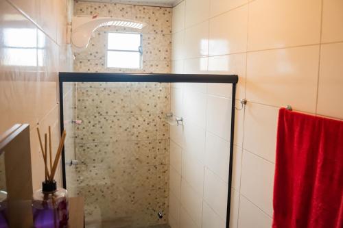 a shower with a red towel in a bathroom at Casa c lazer à 750m da Barra de Santo Antônio AL in Barra de Santo Antônio