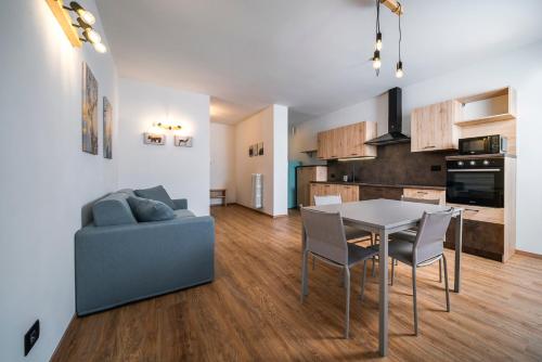 uma cozinha e sala de estar com uma mesa e um sofá em Cauriol Suites 2.3 em Cavalese