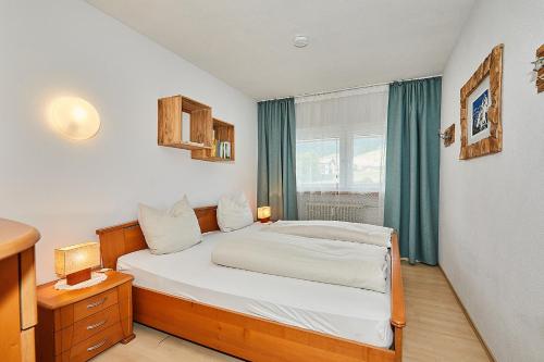 een kleine slaapkamer met een bed en een raam bij Ferienwohnung Allegra in Reit im Winkl