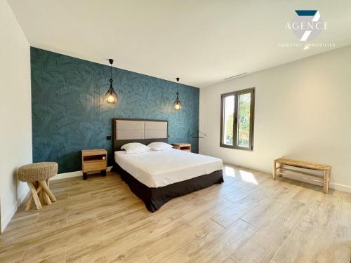 une chambre avec un lit et un mur bleu dans l'établissement Villa Pomme d'Amour, à Sainte-Maxime