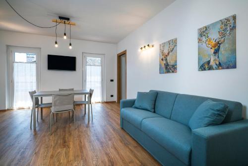 a living room with a blue couch and a table at Cauriol Suites 2.3 in Cavalese