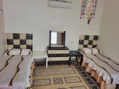 90 qm Wohnung mit 2 Schlafzimmern في مراكش: غرفة بسريرين وخزانة ومرآة