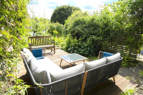 eine Terrasse mit einem Sofa, einem Tisch und einer Bank in der Unterkunft Lovely property in the heart of Somerset, sleeps 9 in Shepton Mallet