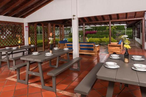 ein Esszimmer mit Tischen und Stühlen auf einer Terrasse in der Unterkunft Chalet La Alemania in Calarcá