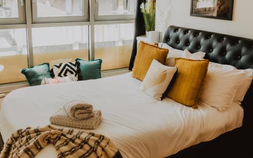 um quarto com uma cama grande e almofadas em Lovely Bohemian Apartment in Heart of City Life em Glasgow