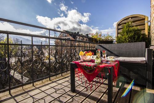 a table with a bowl of fruit on a balcony at Apartamenty Zakopane Krupówki in Zakopane